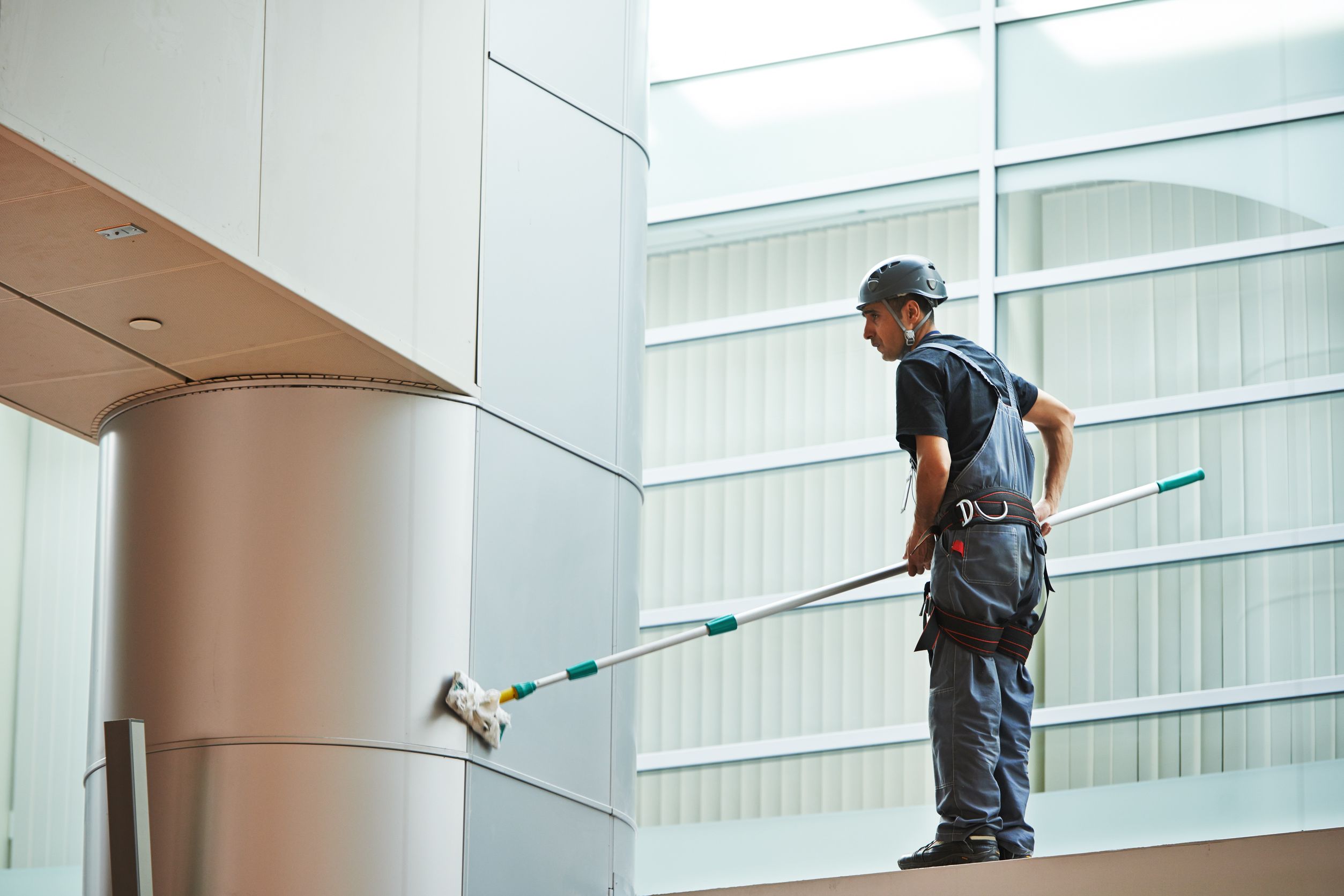 21769655_l-cleaner-worker-in-uniform-cleaning-indoor-window-of-business-building